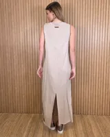 Vestido largo negro de corte holgado, sin mangas y con escote redondo. Presenta detalles de ribetes contrastantes en color beige en los laterales y sisas.