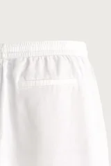 Pantalón de corte relajado confeccionado en una mezcla de algodón y lino. Presenta cintura elástica con cordón ajustable, bolsillos laterales y bolsillos traseros de vivo.