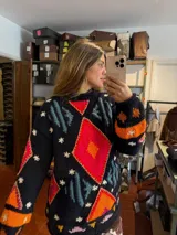 Sweater de punto artesanal en tonos marrones y beige, con diseño geométrico tejido en intarsia y detalles bordados a mano. Presenta cuello redondo y mangas largas.