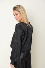 Blusa italiana laminada color dorado, de corte cruzado con elástico en la cintura y mangas largas.