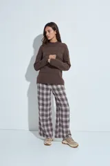 Sweater de punto gris con cuello a la base y diseño de trama geométrica en relieve. Presenta un calce relajado con mangas largas y puños tejidos.