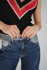 Chaleco calado negro con diseño de rayas diagonales rojas, beige y blancas.