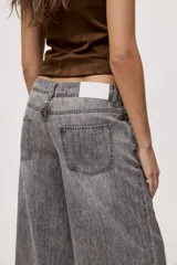Jean wide leg de tiro medio, con pierna amplia de caída recta, diseño de cinco bolsillos, pasacintos y cierre frontal con botón y cremallera.