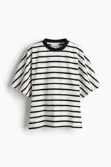 Remera de algodón con rayas horizontales negras sobre fondo blanco. Presenta cuello redondo acanalado negro y mangas cortas amplias.