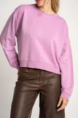Buzo lila oversize confeccionado en 100% algodón, con cuello redondo, mangas largas y puños y dobladillo acanalados. Presenta un pequeño detalle bordado en el bajo.