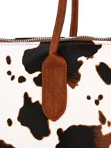 Bolso tipo shopper de la marca Terrano, confeccionado en símil cuero con diseño combinado. Presenta laterales y asas de hombro en color marrón, y panel central con estampado de vaca en blanco y negro. Cuenta con cierre superior y detalles de herrajes metálicos.