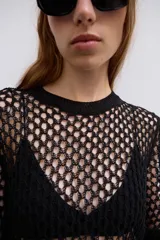 Jersey ajustado de color negro con diseño de punto calado, cuello redondo y mangas cortas.