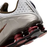 Championes Nike Shox R4, color negro y plateado, con diseño aerodinámico y sistema de amortiguación de columnas Shox en el talón.