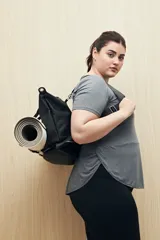 Remera deportiva color lila de manga corta con calce relajado y corte horizontal en la parte inferior.