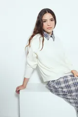 Sweater de punto color blanco, con cuello redondo y diseño texturizado en relieve. Presenta mangas largas y un corte holgado que brinda comodidad y una caída liviana.