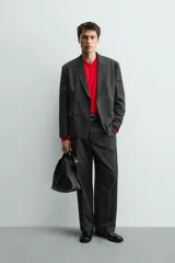 Blazer de corte regular confeccionada en tejido con lana, con diseño de botonadura cruzada. Presenta cuello con solapas de pico, manga larga con puños abotonados, bolsillos de solapa en la cadera y abertura central en la espalda.