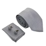 Set de corbata, pañuelo de bolsillo y gemelos color gris con diseño de microcuadros.