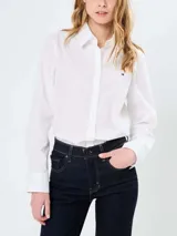 Camisa blanca de manga larga Tommy Hilfiger, de corte regular, con cuello abotonado, cierre con botones y logo bordado en el pecho.