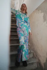 Pantalón palazzo de crepe de seda estampado con motivos florales en tonos fucsia, rojo y blanco. Tiene cierre invisible lateral y costura francesa.