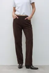 Pantalón tipo jogger de pana color chocolate, con cintura elástica y detalle de vivo en contraste en la parte superior.