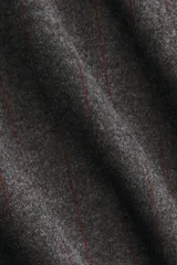 Pollera tubo de tiro alto a la rodilla en tejido de punto grueso color gris con finas rayas verticales rojas, bolsillos al bies y trabillas para cinturón.