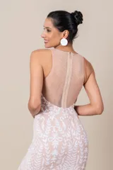 Vestido largo de tul color nude, con bordados blancos de diseño floral. Presenta escote redondo, corte ajustado y falda con vuelo.