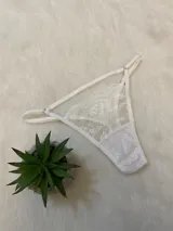 Tanga blanca de encaje con tiras finas regulables.