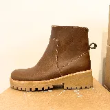 Bota corta de cuero color marrón, con diseño de caña media, costuras reforzadas a la vista y suela track de goma en tono claro.