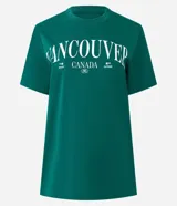 Remera de algodón color verde esmeralda con cuello redondo y mangas cortas. Presenta un estampado frontal en blanco con el texto "VANCOUVER CANADA".
