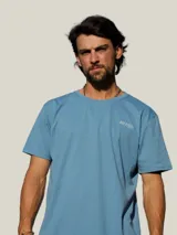 Remera blanca de manga corta con estampa en la espalda en color azul que incluye la frase 'Bo, hay pique!' y dibujos de peces y una caña de pescar.