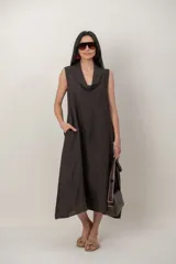 Vestido midi de lino color verde militar, sin mangas, con escote buche y bolsillos laterales, de corte relajado y fluido.