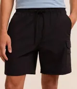 Bermuda masculina color negro, confeccionada en poliamida, con cintura elástica y cordón ajustable. Presenta bolsillos cargo laterales y es de secado rápido.