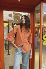 Camisa color naranja con cuello mao, mangas abullonadas 3/4 y corte peplum.