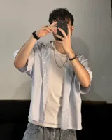 Camisa celeste y blanca a rayas verticales, de corte boxy fit y manga corta.