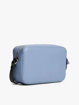 Bandolera Tommy Hilfiger azul con correa ajustable negra, cierre superior y logo dorado de la marca en el frente.