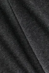 Top de punto fino color gris oscuro, con cuello redondo, costuras decorativas frontales, hombros caídos y mangas al codo. Presenta un corte holgado con bajo levemente acampanado.
