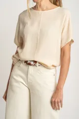 Blusa color crema de poliéster con mangas cortas y corte holgado.