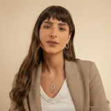 Collar de plata 925 con cadena fina tipo veneciana y un dije colgante de diseño geométrico en forma de ojo o hoja estilizada, compuesto por dos siluetas entrelazadas, una de ellas con detalles de brillo.