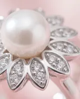 Anillo de plata 925 con diseño floral, compuesto por una perla central rodeada de pétalos decorados con circonias brillantes.