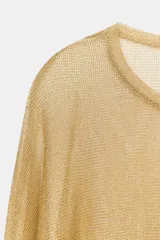 Top de cuello redondo y manga larga, confeccionado en tejido ligero con hilo metalizado de acabado dorado, con bajo recto y diseño holgado.