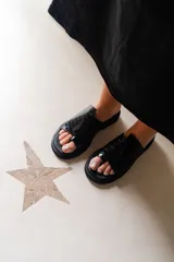 Sandalias negras con diseño de piel de cocodrilo, con tira ancha sobre el empeine y tira entre los dedos.