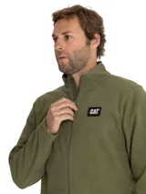 Campera polar de microfleece marca Caterpillar, color verde militar, con cuello alto, cierre frontal completo y bolsillos laterales. Cuenta con el parche bordado del logo de la marca en el pecho.