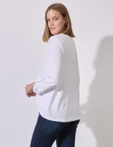 Blusa blanca de poliéster y elastano con textura en relieve, cuello redondo, manga 3/4 con ajuste en el puño y ruedo con nudo.