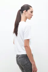 Remera blanca de algodón con cuello redondo y apliques de strass plateados.