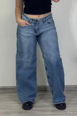 Pantalón jean celeste de tiro medio, corte ancho y estilo baggy.