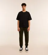 Pantalón de jogging verde oscuro, con cintura elástica ajustable con cordón, bolsillos laterales y puños elásticos.