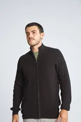 Campera tejida de algodón con cierre frontal completo, cuello alto y mangas largas con puños acanalados. Presenta un diseño de punto acanalado vertical y un pequeño logo bordado en el ruedo.