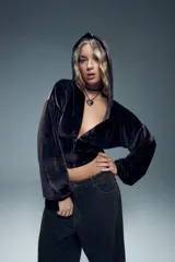 Canguro corto de terciopelo marrón chocolate, con capucha, cierre frontal metálico y mangas largas abullonadas con puños elásticos.