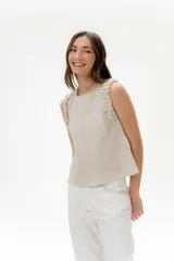Musculosa de lino color beige claro, con escote redondo y volados fruncidos en los hombros.