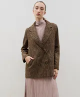 Blazer de lana con diseño bicolor, cuerpo en color negro y mangas en color crema. Presenta un corte holgado, cierre cruzado con doble botonadura y solapas amplias en contraste.