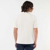 Remera polo de piqué de algodón en color beige, con cuello camisero y cierre frontal de botones.