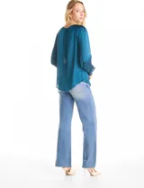 Blusa de satén color verde azulado con acabado sedoso y fluido. Escote a la base con frunce perimetral, mangas largas estilo balloon con detalle de punto smock en hombros y puños. Espalda con abertura tipo gota y botón forrado a tono.