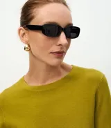 Suéter de punto ajustado con cuello redondo y manga larga. Presenta detalle de botones metalizados en los puños.