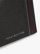 Billetera plegable Tommy Hilfiger de piel granulada negra, con detalle frontal de costuras decorativas tricolores y logotipo metálico de la marca en relieve.