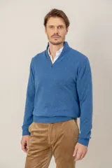 Sweater de punto en lana lambswool color azul, con cuello alto y cierre frontal parcial. Presenta puños y ruedo acanalados.